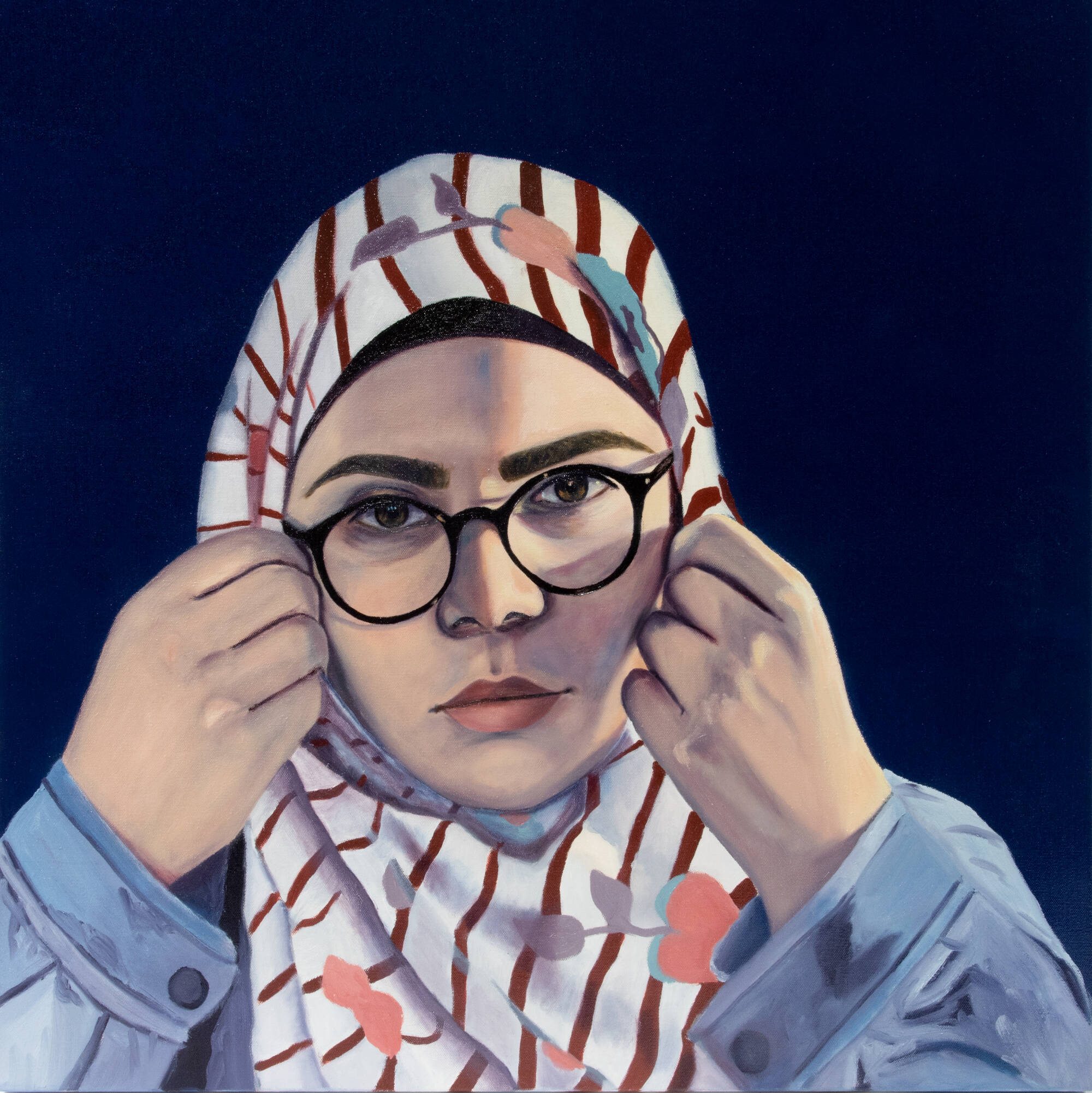 Portrait of a woman with glasses, holding the edges of her head covering.